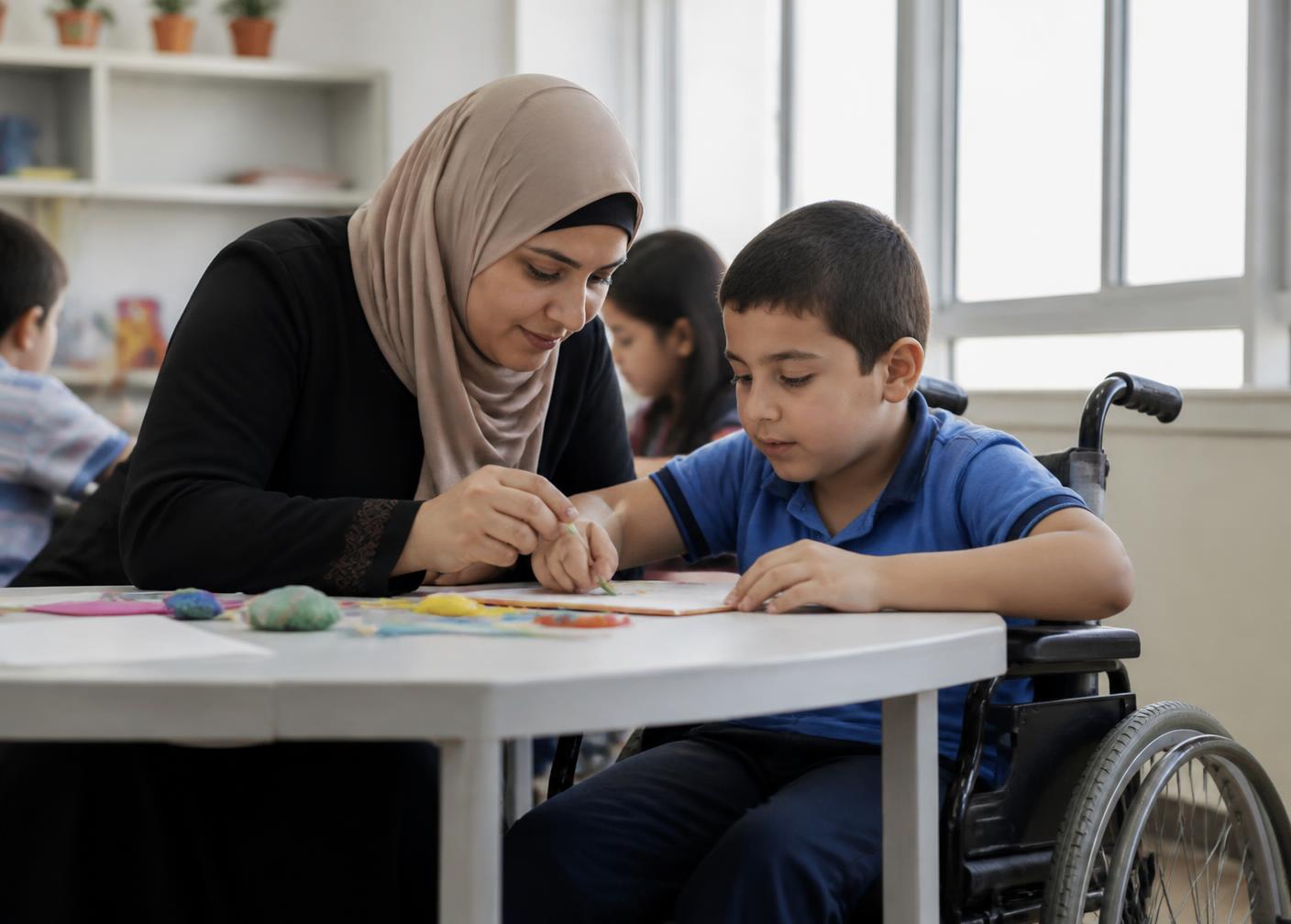 معلمة تساعد طالبًا من ذوي الإعاقة داخل صف دامج